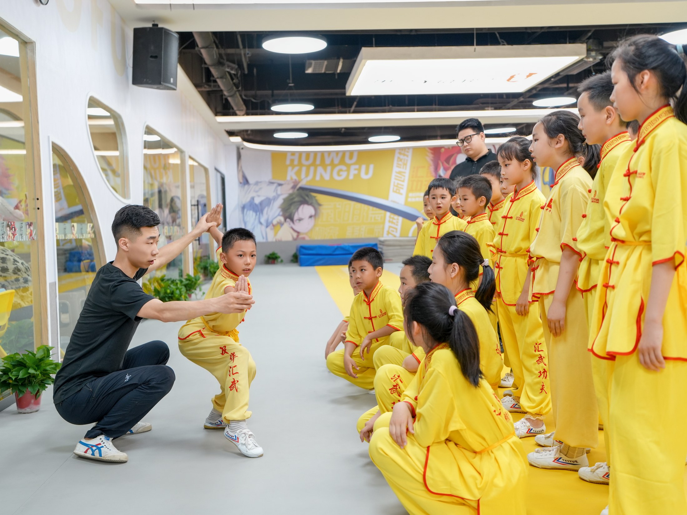 汇武功夫教练为学员示范动作，孩子们专注观看