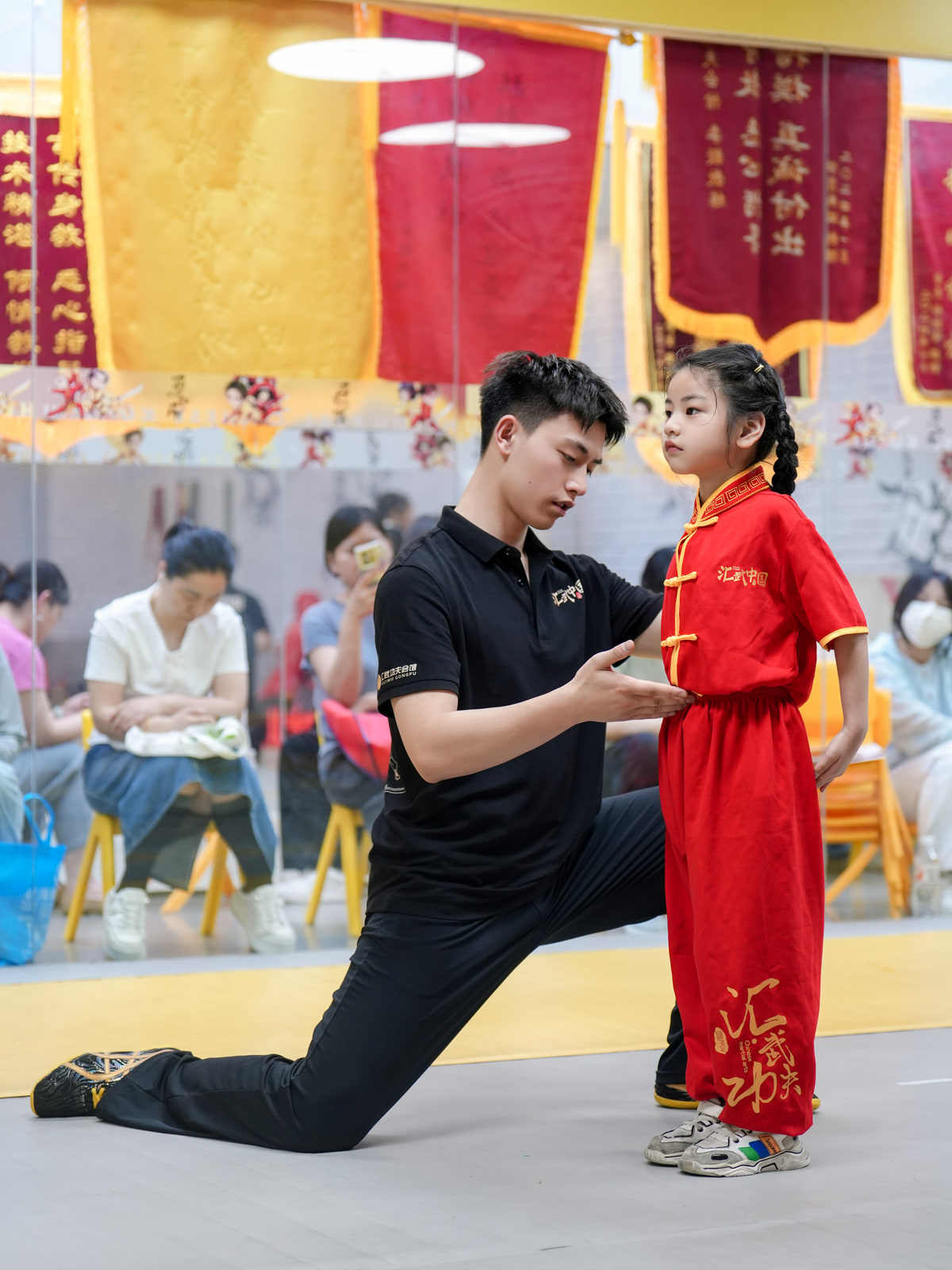 教练在课堂上指导低龄学员调整武术动作