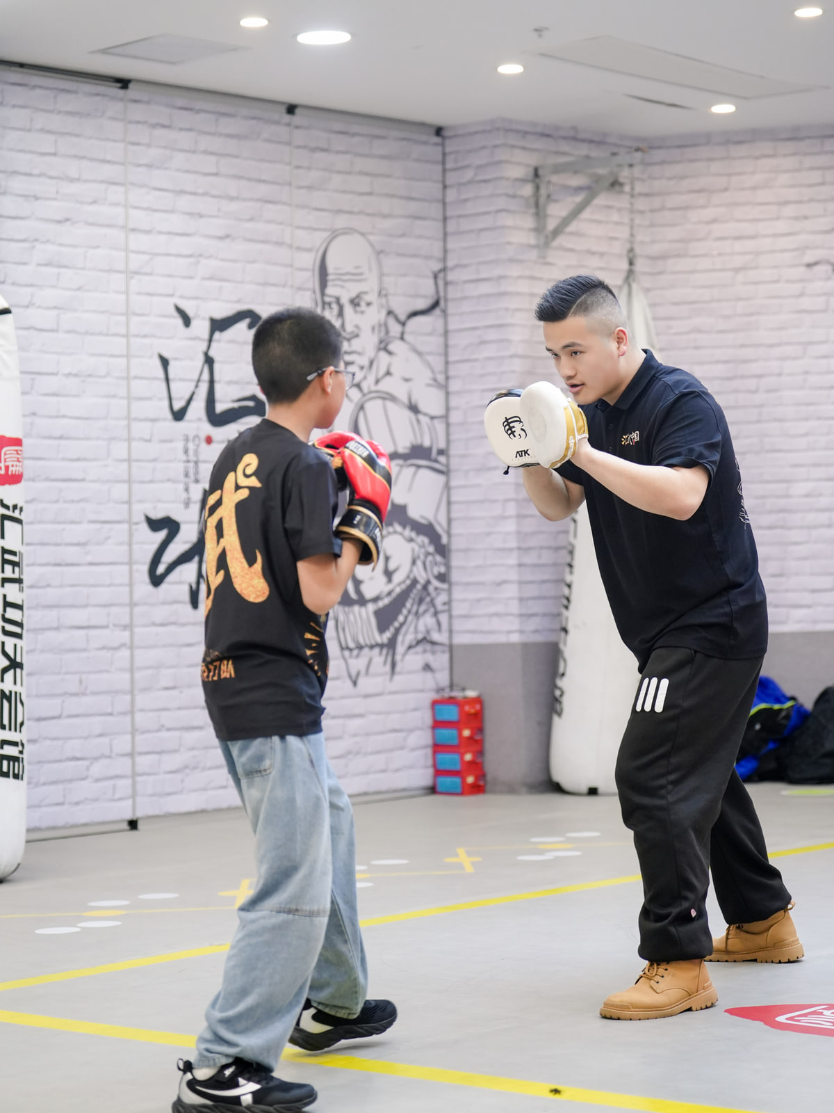 青少年学员与教练进行散打拳法训练